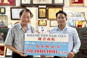 庆云南院住持周华邦（左）将5000万元赞助经费移交予《西贡解放报》采编部主任、华文电子版负责人文忠孝。VD摄