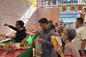善信携带供品前来祭拜先人，并依序上香祈福。