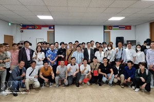 在昌原（韩国）的越南劳动者与各组织方和赞助方代表在提高昌原越南劳动者法律知识咨询会上合影留念。图自越通社