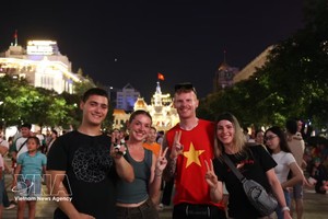 外国游客融入胡志明市市中心国庆夜晚的热闹氛围。图自越通社