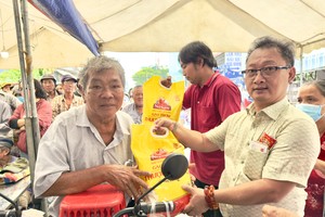 富山五行庙慈善组组长邹国荣向残疾人士派发盂兰节赈济品。