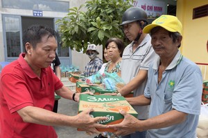 决胜村关帝庙理事长杨振明向清贫户发放盂兰节礼物。