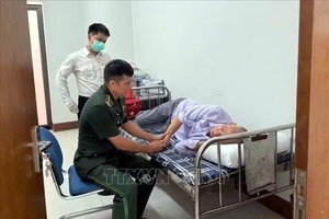 芒街国际口岸边防检查站干部与国际卫生检疫人员配合，对昏厥的中国籍旅客梁睿壮进行初步救治。图片：越通社