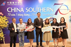 中国南方航空胡志明市营业部总经理黄翔（中）、副经理雷远志（左一）与客户合照留念。VD摄
