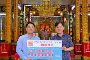 海南会馆理事长林明辉（右）将5000万元赞助经费移交予《西贡解放报》采编部主任、华文电子报负责人文忠孝。