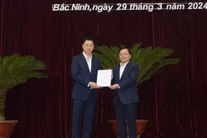 Bí thư Tỉnh ủy Bắc Ninh Nguyễn Anh Tuấn trao quyết định của Ban Bí thư cho ông Trần Huy Phương (bên trái)