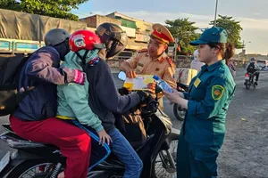 Trạm CSGT Tân Túc tặng nước, phát tờ rơi tuyên truyền cho người dân về quê nghỉ lễ
