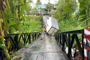 Cầu bị gãy đoạn giữa, một ô tô tải bị kẹt giữa cầu. Ảnh: PM