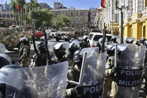 Xe thiết giáp của binh sĩ Bolivia đang rút khỏi dinh Tổng thống. Ảnh: Reuters