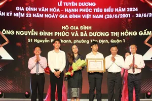 Đồng chí Huỳnh Thanh Nhân, Phó Chủ tịch HĐND TPHCM và đồng chí Phạm Minh Tuấn, Phó Chủ tịch UBMTTQ Việt Nam TPHCM, trao tặng Bằng khen của UBND Thành phố và hoa cho các gia đình đạt danh hiệu Gia đình văn hóa – Hạnh phúc tiêu biểu năm 2024. Ảnh: DŨNG PHƯƠNG