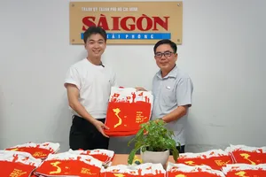 Anh Đinh Xuân Dương, CEO FlyG Entertainment (áo trắng) tặng Báo Sài Gòn Giải Phóng 200 túi xách in hình bản đồ đất nước. Ảnh: VIỆT NGA