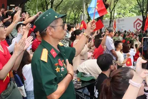 Người dân tại khu vực chợ Bến Thành dõi theo Lễ kỷ niệm 50 năm Ngày Giải phóng miền Nam, thống nhất đất nước. Ảnh: CẨM TUYẾT