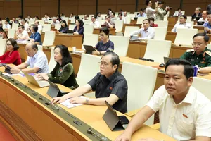 Đại biểu Quốc hội bấm nút thông qua dự luật sáng 16-6. Ảnh: QUANG PHÚC