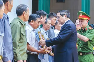 Thủ tướng Phạm Minh Chính trao thông báo kết quả giám định ADN hài cốt liệt sĩ đến đại diện gia đình liệt sĩ tại hội nghị. Ảnh: VIẾT CHUNG 