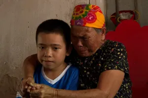 Bà Từ Thị Thà và cháu nội trong ngôi nhà lụp xụp