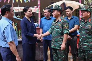 Bà Hà Thị Nga, Phó Chủ tịch Ủy ban Trung ương MTTQ Việt Nam động viên lực lượng vũ trang đang hỗ trợ nhân dân vùng lũ