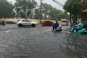 Xe cộ chật vật di chuyển trong dòng nước cuồn cuộn giữa phố Đà Nẵng. Ảnh: XUÂN QUỲNH