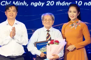 Phó Trưởng Ban Tuyên giáo và Dân vận Thành ủy TPHCM Lê Văn Minh, Phó Giám đốc Sở VH-TT TPHCM Nguyễn Thị Thanh Thúy, tặng hoa và quà lưu niệm cho nhà thơ Hoài Vũ. Ảnh: THÚY BÌNH