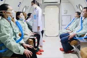 Nhân viên y tế đang hướng dẫn người bệnh đo chức năng hô hấp