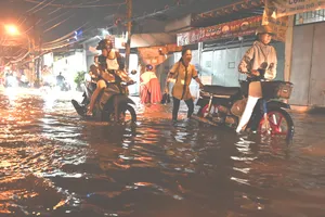 Triều cường dâng cao, người dân bì bõm lội nước về nhà