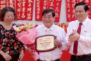 Phó Tổng Biên tập Báo Sài Gòn Giải Phóng Nguyễn Ngọc Anh và Phó Chủ tịch Thường trực Hội Văn học nghệ thuật các dân tộc thiểu số TPHCM tặng Kỷ niệm chương cho Trưởng Ban Quản trị Hội quán Nhị Phủ Bành Huy Cường. Ảnh: THÚY BÌNH