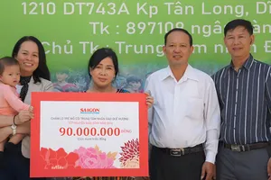 Đại diện Báo Sài Gòn Giải Phóng trao bảng tượng trưng chăm lo Tết Nguyên đán Bính Ngọ 2026 cho trẻ mồ côi Trung tâm Nhân đạo Quê Hương. Ảnh: VIỆT NGA