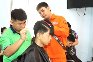 Anh Nguyễn Tuấn Thanh (phải) hướng dẫn em Lê Hữu Đạt nghề cắt tóc. Ảnh: THÁI PHƯƠNG