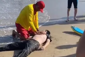 Nhân viên cứu hộ bãi biển đang sơ cứu du khách bị đuối nước