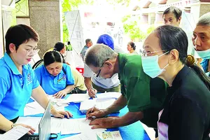 Chuyên viên BHXH TPHCM tư vấn chính sách BHYT, BHXH cho người dân (ẢNH: ĐÔNG SƠN)