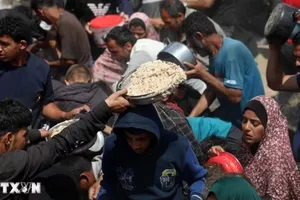 Người dân nhận thực phẩm cứu trợ tại Gaza. (Ảnh: THX/TTXVN)