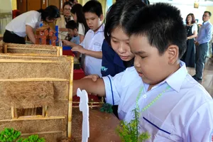 Học sinh Trường Phổ thông đặc biệt Nguyễn Đình Chiểu trải nghiệm sờ, chạm vào các mô hình sân khấu của câu chuyện "Sự tích trái thơm" tại chương trình. Ảnh: THÚY BÌNH