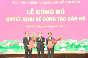 PGS-TS Lê Hải Bình trao quyết định và tặng hoa chúc mừng lãnh đạo Học viện Báo chí và Tuyên truyền. Ảnh: HVBC