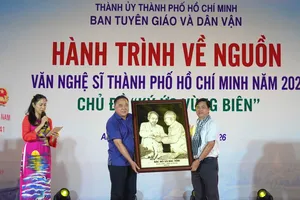 Bí thư Đảng ủy, Chủ tịch HĐND xã Ba Chúc Phạm Minh Hiền tặng bức tranh "Bác Hồ và Bác Tôn" cho Phó Trưởng Ban Thường trực Ban Tuyên giáo và Dân vận Thành ủy TPHCM Lê Văn Minh. Ảnh: THÚY BÌNH