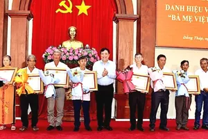 Đồng chí Phạm Thành Ngại, Chủ tịch UBND tỉnh Đồng Tháp, trao bằng công nhận và hoa cho thân nhân các Bà mẹ Việt Nam Anh hùng. Ảnh: VIỆT TIẾN