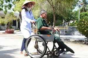 Nhân viên Trung tâm Điều dưỡng Thương binh và Người có công Long Đất chăm sóc thương binh. Ảnh: NGUYỄN NAM