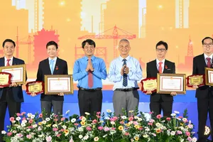 Đồng chí Đặng Ngọc Tùng và đồng chí Bùi Thanh Nhân chúc mừng các gương đoạt Giải thưởng Tôn Đức Thắng lần thứ 26. Ảnh: VIỆT DŨNG