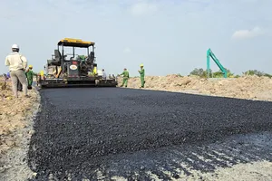 Công nhân đổ bê tông nhựa tại đường nhánh vào cao tốc Châu Đốc - Cần Thơ - Sóc Trăng