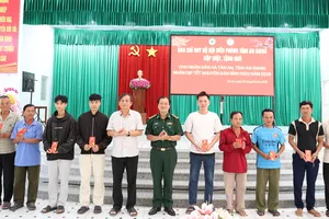 Đại tá Lê Hoàng Việt, Phó Chính ủy Ban Chỉ huy Bộ đội Biên phòng tỉnh An Giang và lãnh đạo địa phương trao quà cho bà con xã Tân An