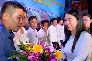 A representative of Cu Chi goverment presents flower to fund contributors at the event (Photo: SGGP)