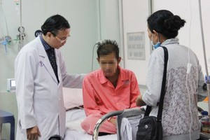A medical worker talks to the Cambodian man about his health condition (Photo: SGGP)