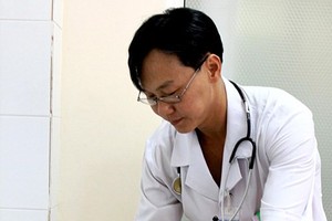 A doctor takes care of his elderly patient (Illustrative photo: VNA)