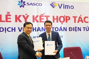 Representatives of Vimo and SASCO sign an agreement on launching electronic payment services for Asian tourists when travelling into Vietnam. — (Source: ictnews.vn)