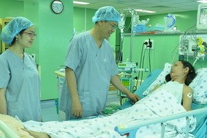 Medical workers talk to the patient after the operation (Photo: SGGP)