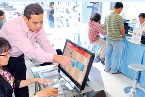 Officers of the People’s Committee of Ben Thanh Ward (District 1, Ho Chi Minh City) are helping citizens to use their fingerprint to check information and register for civil-status-related, real-estate-related, and copy-certifying-related activities (Phot