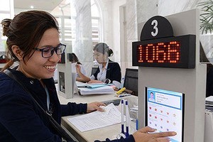 Citizens rate their level of satisfaction with government officials in the People’s Committee of District 1. Photo by Viet Dung
