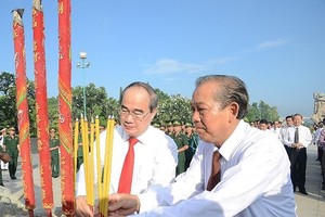 Politburo member and Standing Deputy Prime Minister Truong Hoa Binh (R) and Politburo member and Secretary of the Ho Chi Minh City Party Committee Nguyen Thien Nhan offer incense to heroic martyrs (Photo: plo.vn)