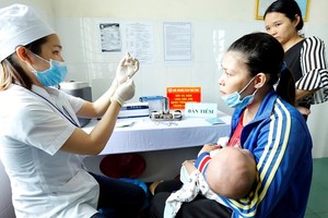 A medical worker prepares to administer vaccine to a baby in the Central Highlands province of Dak Lak (Photo: VNA)