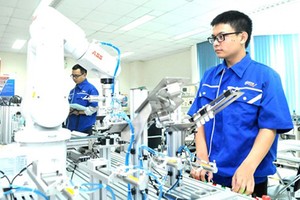 Students are monitoring robots and automatic production systems in SHTP. Photo by CAO THANG.