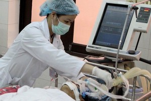 A medical worker tends a patient (Photo: VNA)