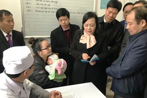 Health Minister Nguyen Thi Kim Tien at a medical clinic talks about vaccination benefit to parents ( Photo SGGP)